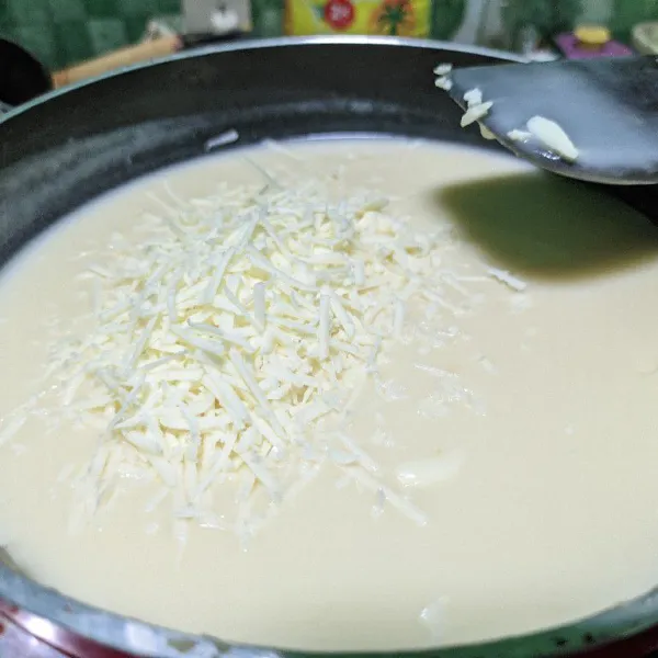 Masukkan susu cair dan parutan keju, aduk merata.