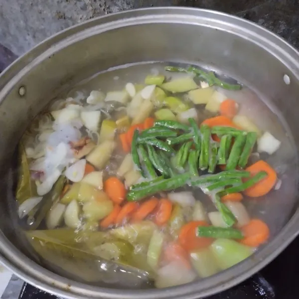 Masukkan wortel dan kacang panjang, rebus hingga wortel hampir empuk.