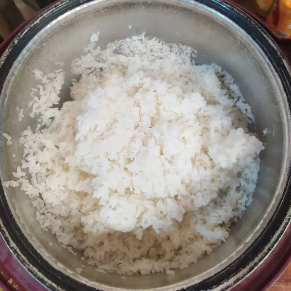 Cuci beras lalu masak di magic com. Setelah matang aduk nasi supaya pulen.