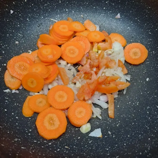 Masukkan wortel, irisan tomat dan air secukupnya. Masak sampai wortel ½ matang.
