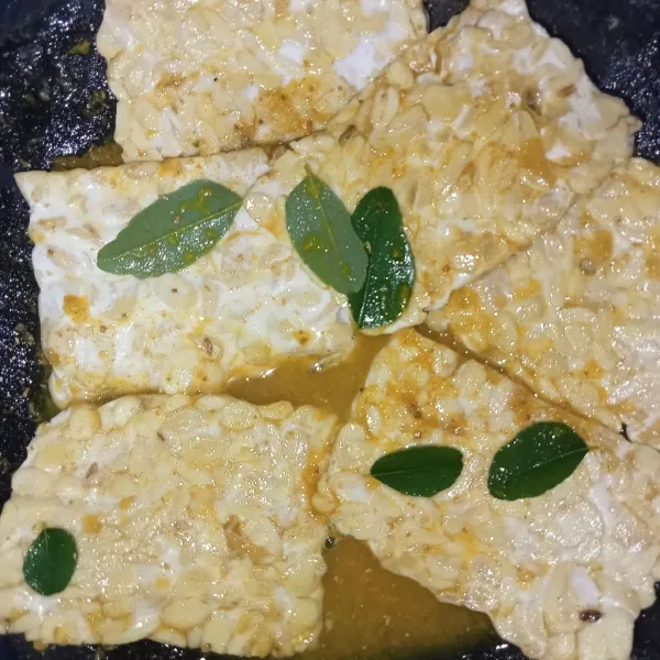 Masukkan tempe kedalam bumbu bolak balik tempe supaya bumbu meresap masukkan daun kari.