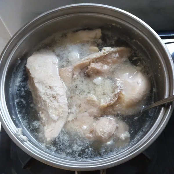 Rebus dada ayam hingga empuk, kemudian angkat dan tiriskan.