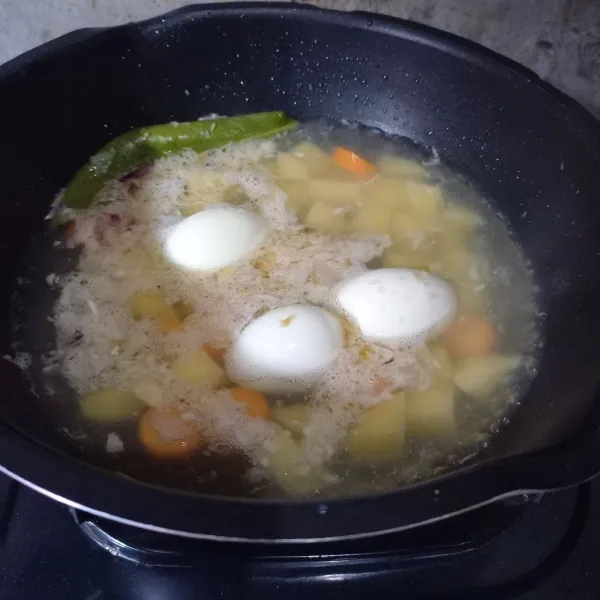 Masukkan kentang, wortel dan telur.