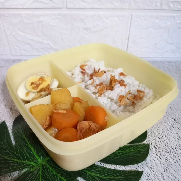 Siapkan tempat bekal. Isi dengan nasi, semur dan taburan bawang merah goreng.