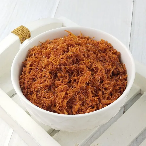 Hidangan ayam yang sudah dimasak berwarna keemasan dengan bumbu rempah tersaji di atas piring putih bersih