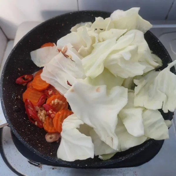 Masukkan wortel yang sudah direbus dan potongan kubis, aduk rata.