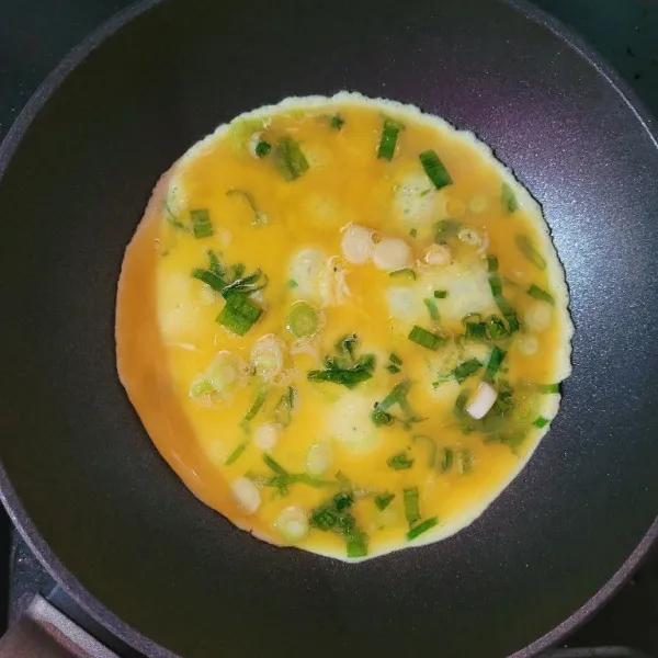 Goreng telur dengan sedikit minyak dengan bentuk lingkaran.