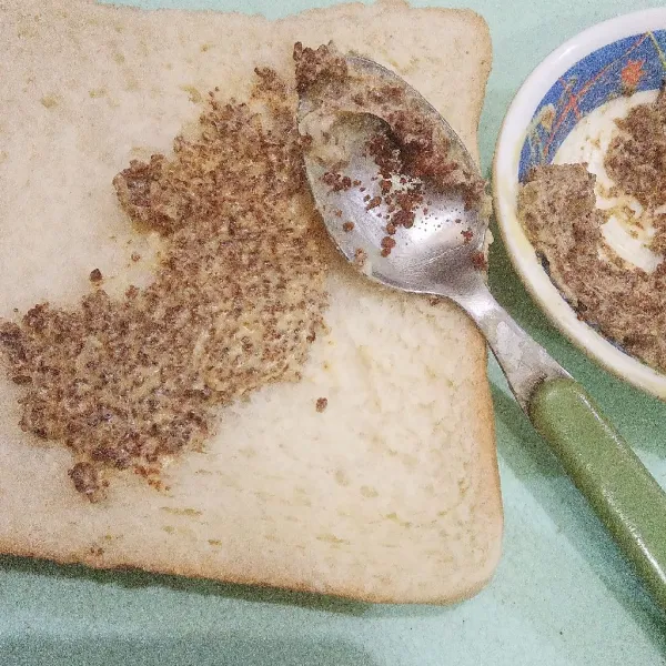 Oles campuran mentega dan brown sugar di satu sisi secara merata di setiap lembar roti tawar.