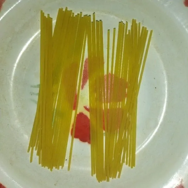 Siapkan spaghetti, lalu potong spaghetti menjadi 2 bagian yang sama, lalu sosisnya dipotong menjadi 2 bagian pula.