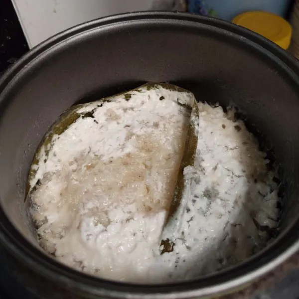 Masukkan beras ke dalam wajan rice cooker, beri santan, daun pandan, tambahkan air sesuai tarakan memasak nasi, lalu beri garam. Aduk rata dan masak di rice cooker hingga matang, lalu aduk rata.