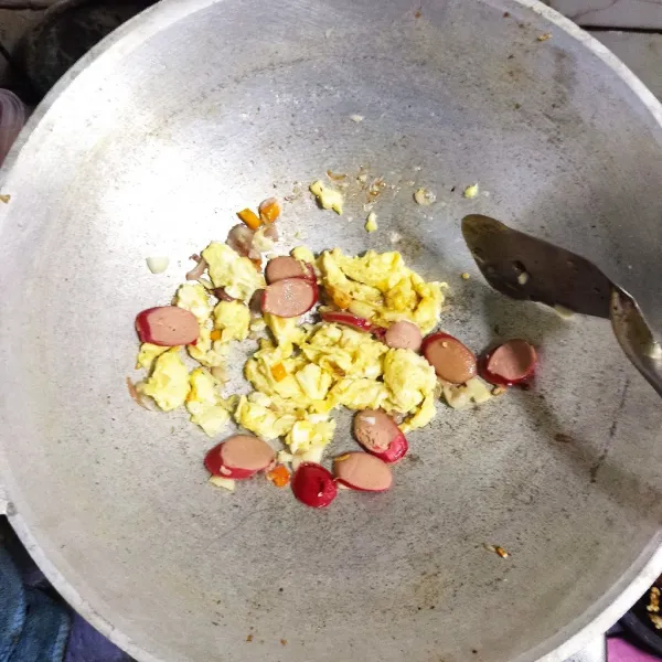 Masukkan kocokan telur lalu orak arik telur. Masukkan potongan sosis. Masak hingga sosis empuk.