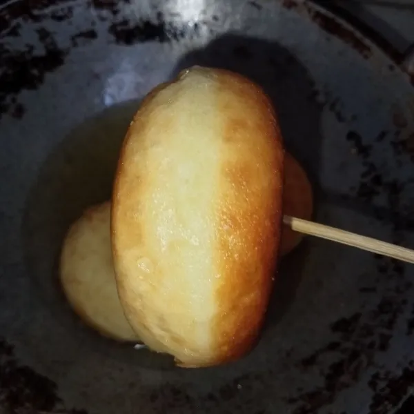 Panaskan minyak lalu goreng donat hingga kuning keemasan, tiriskan.