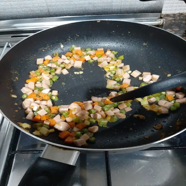 Masukan sayuran dan sosis, masak hingga ½ layu.
