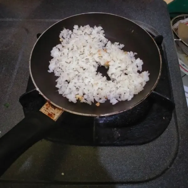 Setelah itu masukkan nasi dan garam, kemudian aduk rata.