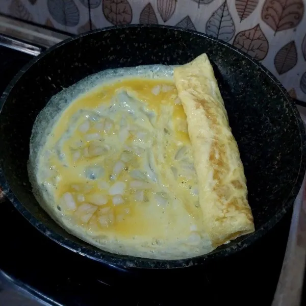 Tuang sedikit campuran telur di sampingnya. Lalu gulung lagi. Lakukan sampai habis. Masak sampai sisi-sisinya kecokelatan.