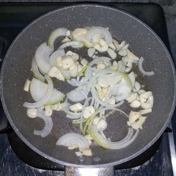 Tumis bawang bombai dan bawang putih sampai layu.