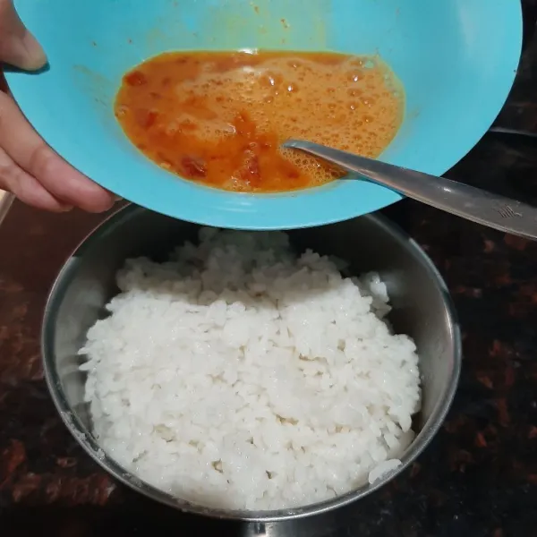 Tempatkan nasi dalam wadah bekal lalu aduk dengan 1 butir telur yang sudah di kocok dengan sambal.