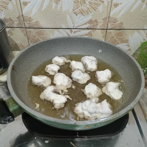 Goreng cumi yang sudah diberi adonan tepung, sampai matang.