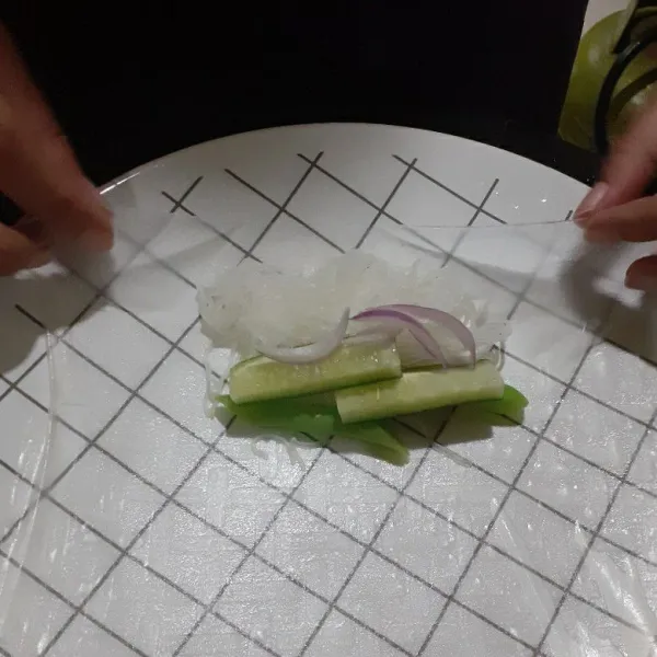 Beri bihun, bombay merah / bawang merah India, buncis, timun, dan telur. Lalu lipat dan gulung. Lakukan sampai habis.