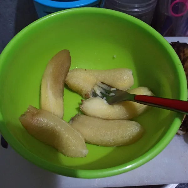 Siapkan pisang lalu haluskan dengan garpu.