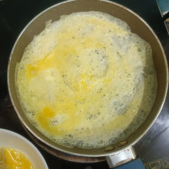 Kocok lepas telur beri tambahan garam dan kaldu bubuk, kocok lagi, kemudian dadar telur tipis tipis, angkat dan sisihkan.