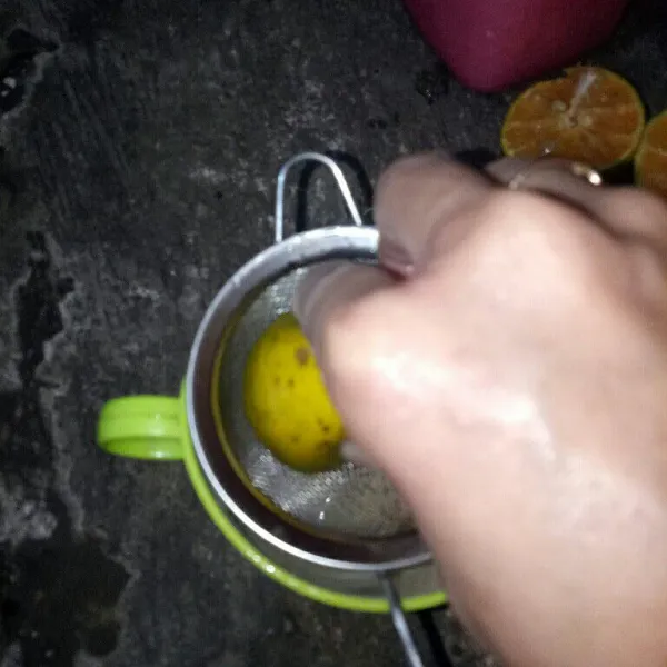 Belah jeruk menjadi 2 lalu peras kedalam gelas sisihkan