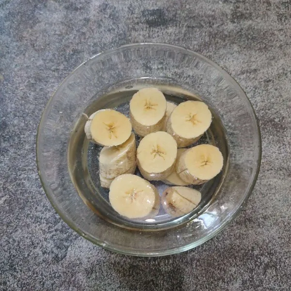 Kupas pisang lalu rendam dengan air agar tidak hitam, kemudian potong-potong.