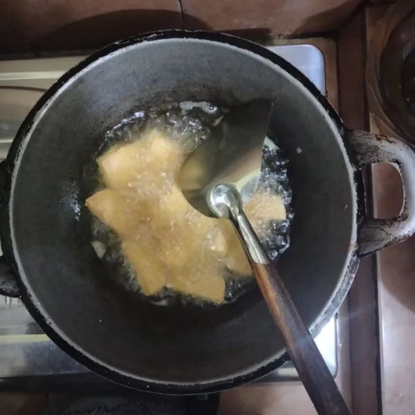 Goreng tahu putih hingga kuning kecoklatan, lalu angkat dan tiriskan.