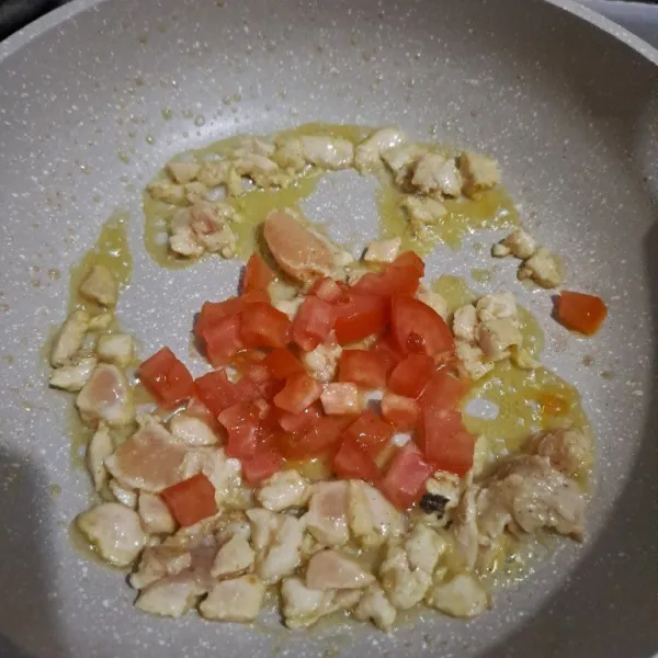 Tumis bawang putih sampai harum masukan ayam tumis sampai berubah warna lalu masukan tomat.