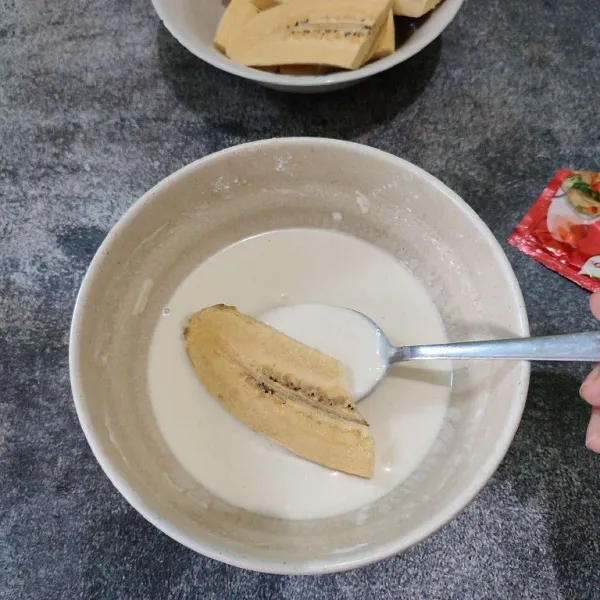 Masukkan potongan pisang ke dalam adonan tepung.