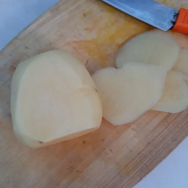Potong pinggiran kentang dan iris menjadi beberapa bagian.