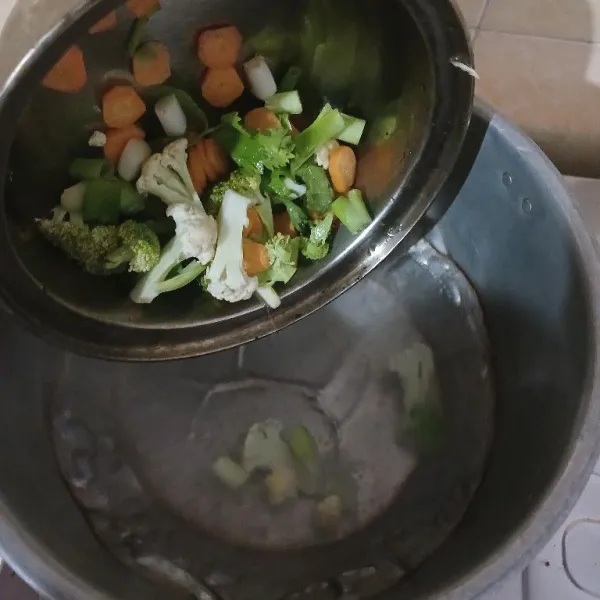 Rebus air kira kira cukup untuk membuat 2 mie, masukkan sayuran masak hingga layu.