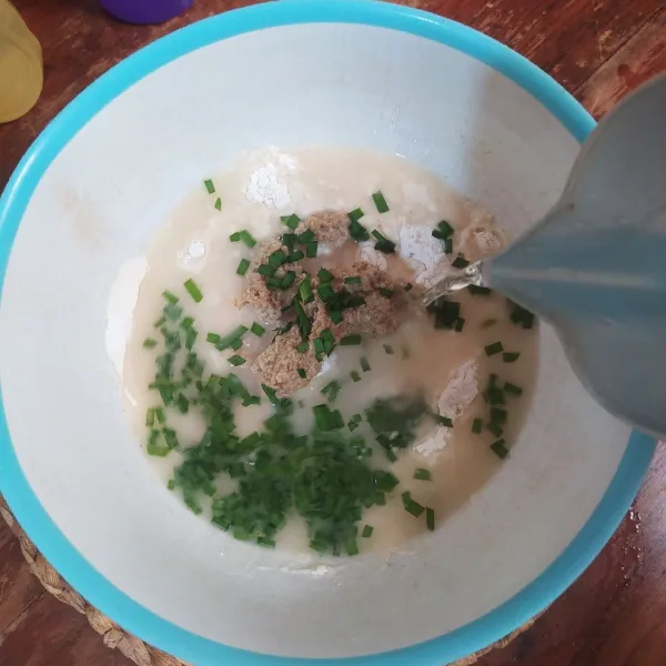 Masukkan ke dalam wadah berisi tepung terigu, tepung beras dan irisan daun bawang. Tuang air, aduk rata.