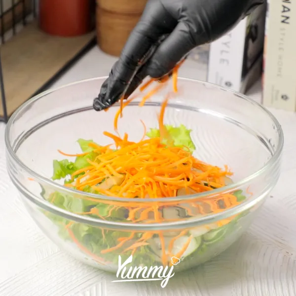 Campurkan selada, timun, wortel dan jagung manis di dalam wadah.