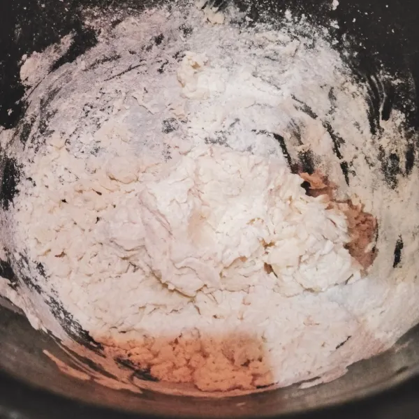 Masukkan air ragi (aduk terlebih dahulu) ke dalam tepung terigu, lalu uleni.