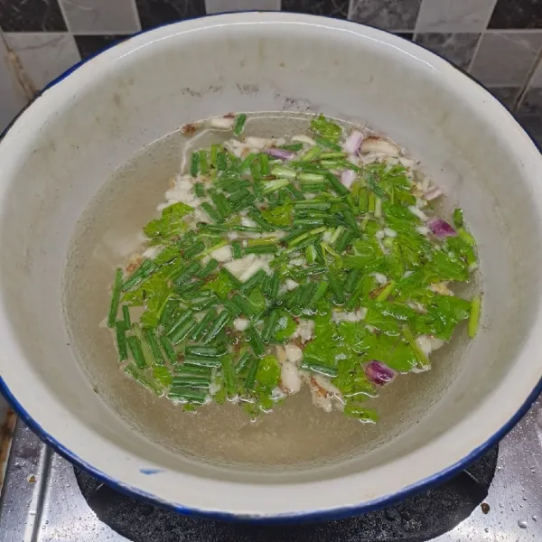 Rebus air sampai mendidih, masukkan bawang putih cincang, seledri dan daun bawang. Rebus sampai aromanya harum.