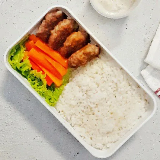 Angkat lalu tata dalam wadah bekal bersama, nasi, sayuran, dan sausnya.