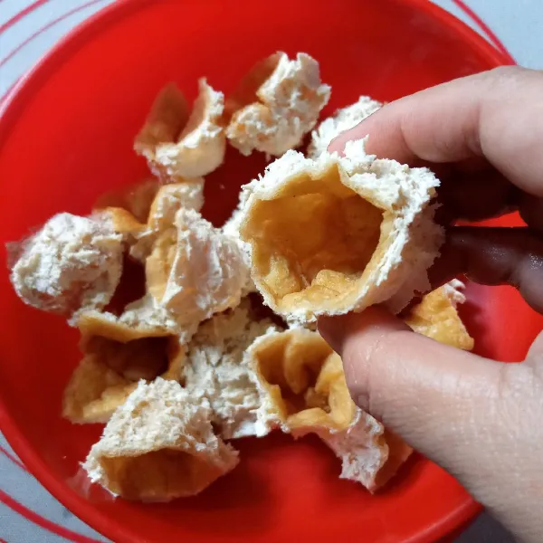 Potong tahu jadi dua kemudian balik. Jika bagian putihnya terlalu padat bisa dikerok terlebih dahulu kemudian dibalik.