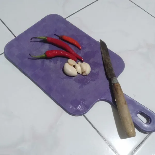 Rebus mie keriting hingga matang, lalu angkat, tiriskan, dan sisihkan dulu. Cincang bawang putih, cabai merah dan cabai kecil.