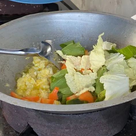 Setelah bumbu dan telur menyatu, masukkan sayuran dan tumis hingga layu.