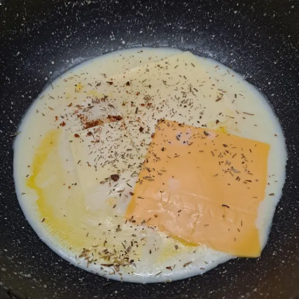 Tuang susu cair, beri keju oles, keju slice, dan keju quickmelt. Bumbui pala bubuk dan mix italian herbs.