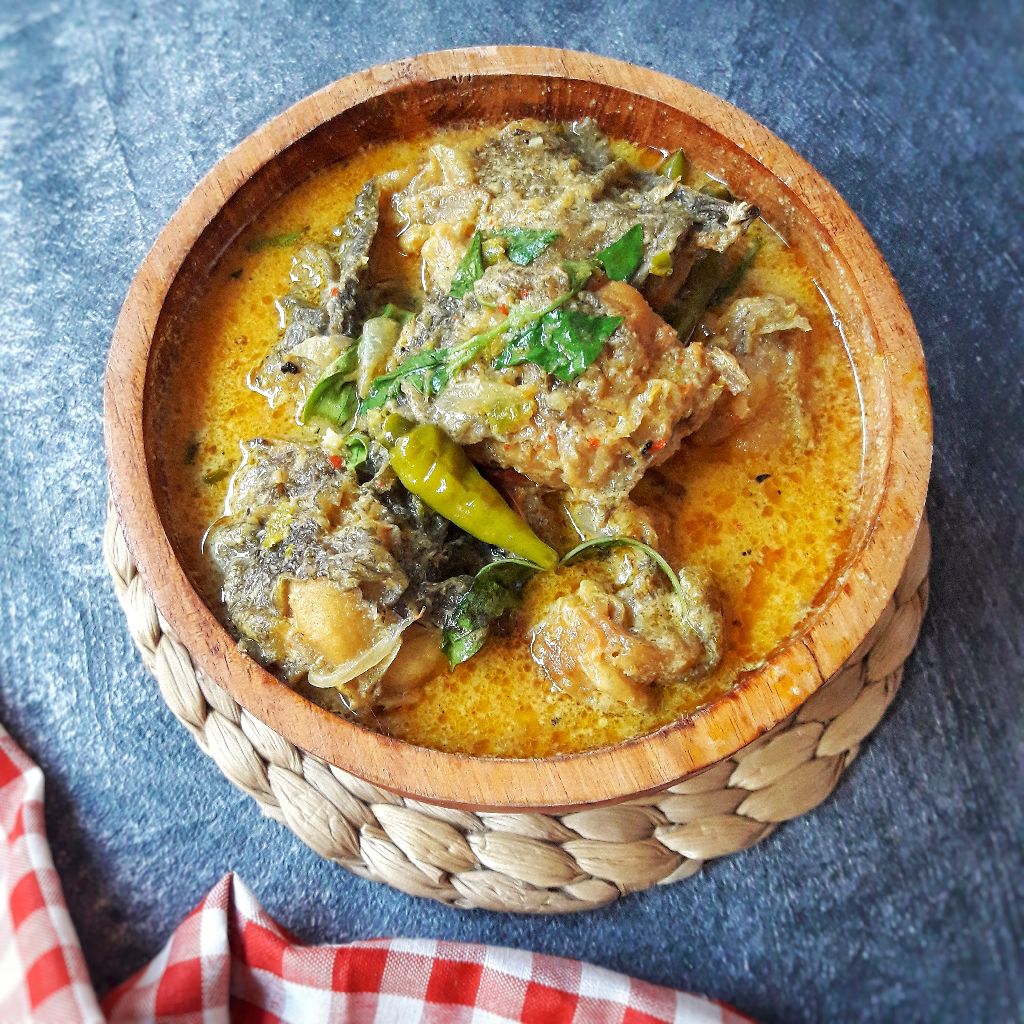 Mangut lele dalam piring saji dengan taburan daun kemangi