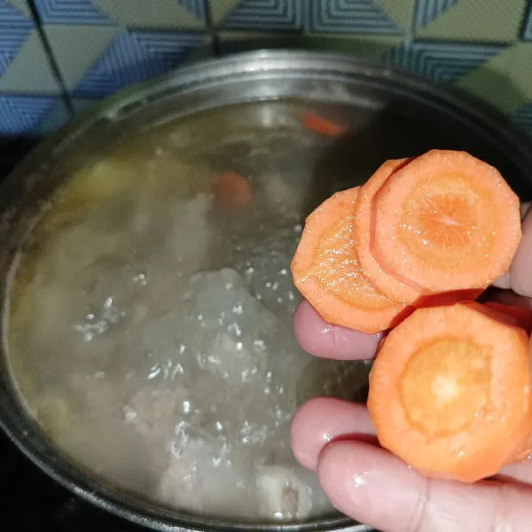 Tambahkan wortel dan aduk rata, masak sampai ayam matang dan empuk.