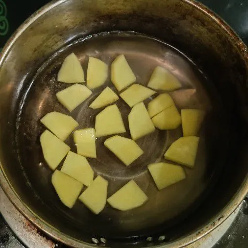 Kupas dan potong potong kentang, lalu rebus hingga empuk. Kemudian angkat dan tiriskan.