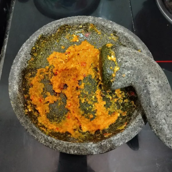 Masukkan bumbu ke dalam cobek, lalu haluskan.