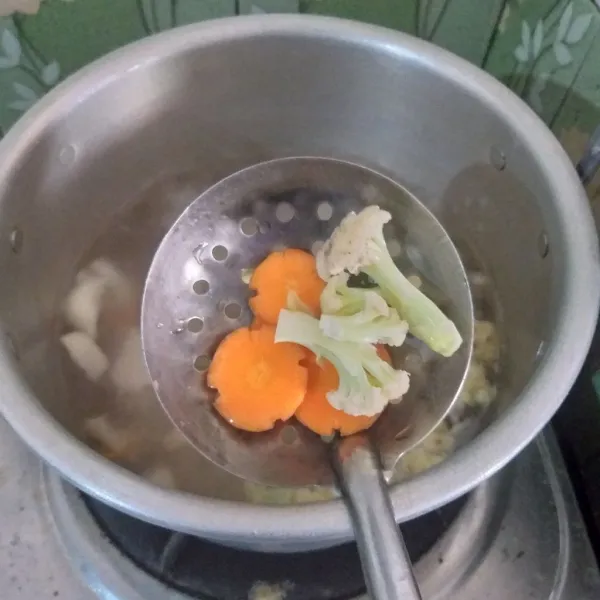 Masuk wortel dan bungkul, masak hingga sayuran agak lunak.