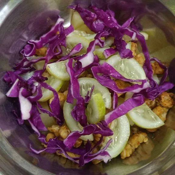 Siapkan wadah, lalu masukkan kentang rebus, tempe, irisan timun, dan irisan kol ungu.