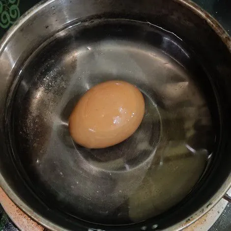 Rebus telur selama 7 menit, kemudian angkat dan masukkan ke dalam air es. Kemudian baru kupas dan belah jadi dua.