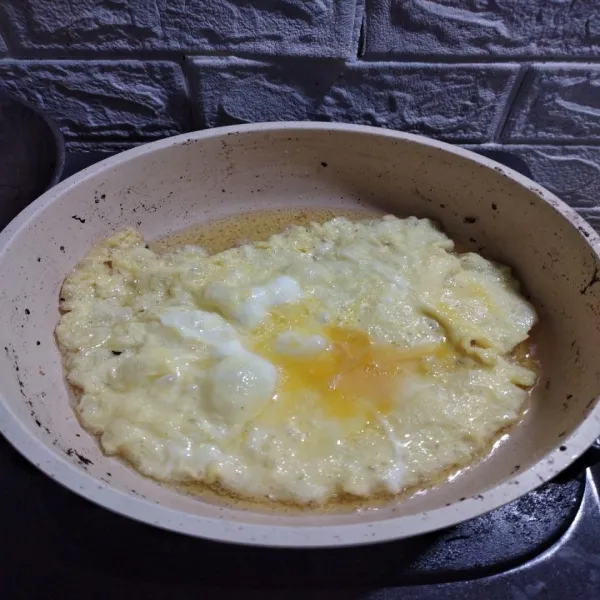 Kocok telur, bubuhi kaldu penyedap, panaskan minyak, buat dadar telur.