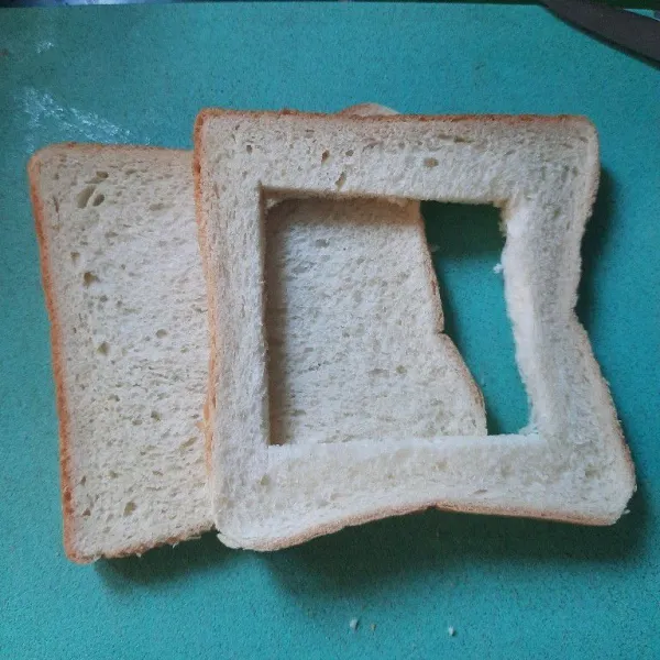 Siapkan 2 lembar roti yang satu beri lubang kotak.